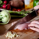 Person cutting into raw chicken breast